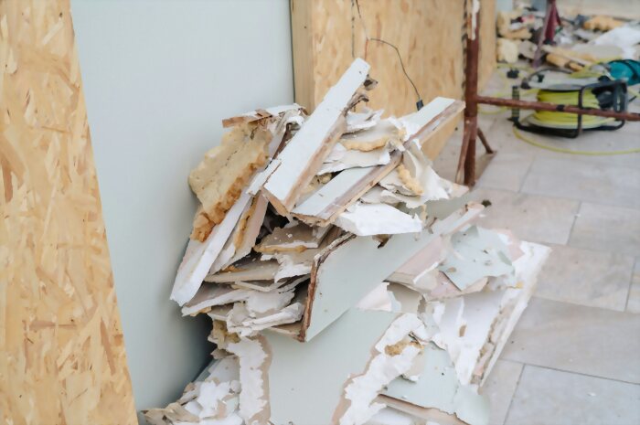 Removed drywall and flooring stacked for disposal